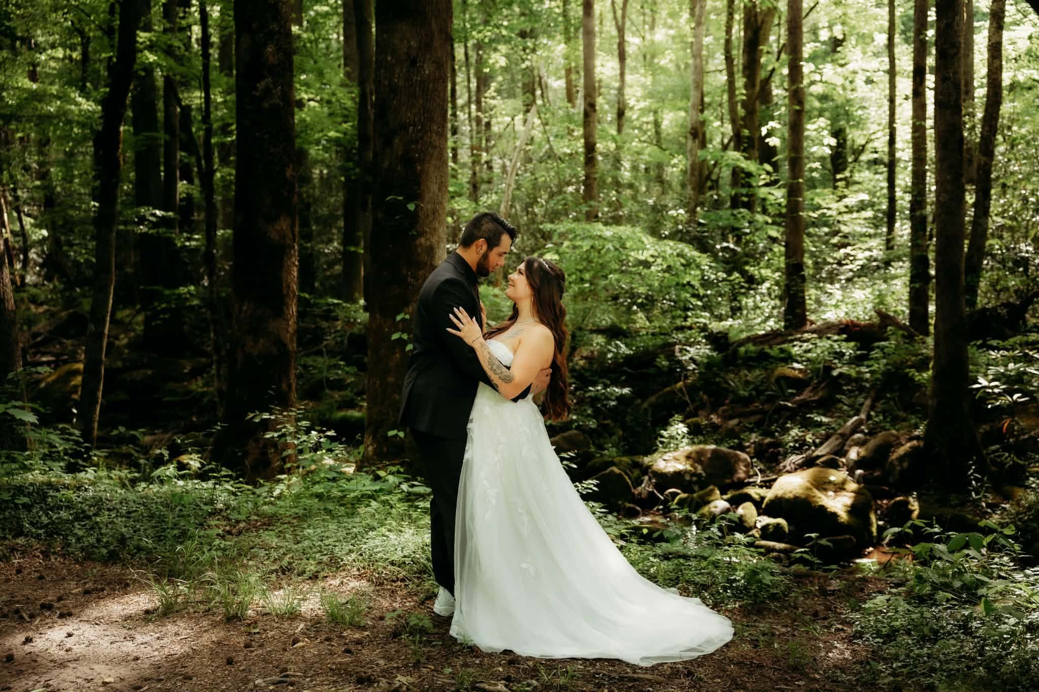 Bride and groom embracing in a sunlit forest
