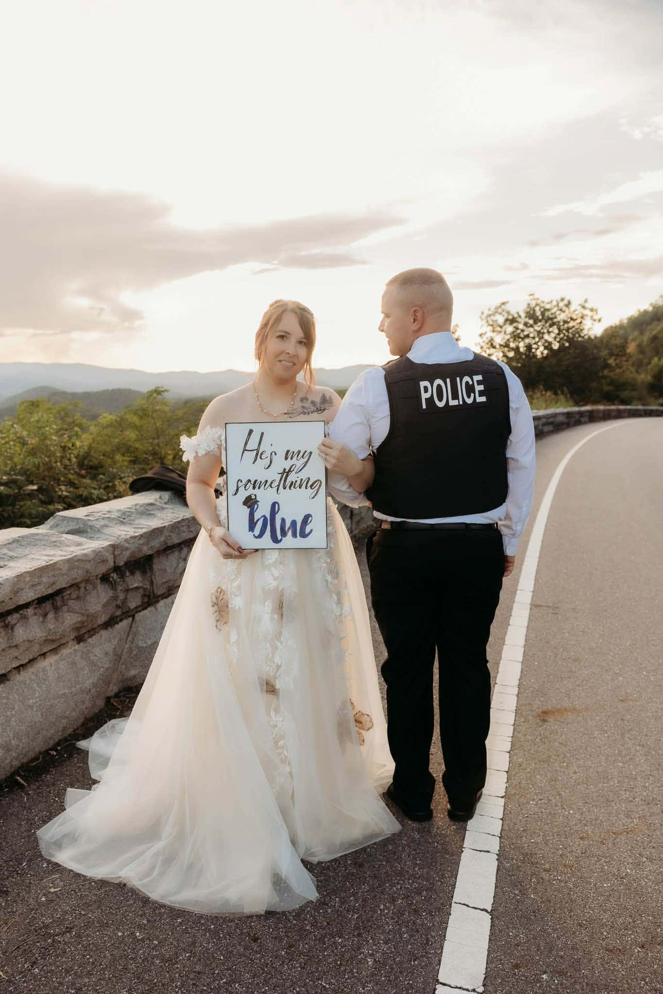 Bride and police officer groom holding humorous elopement signs
