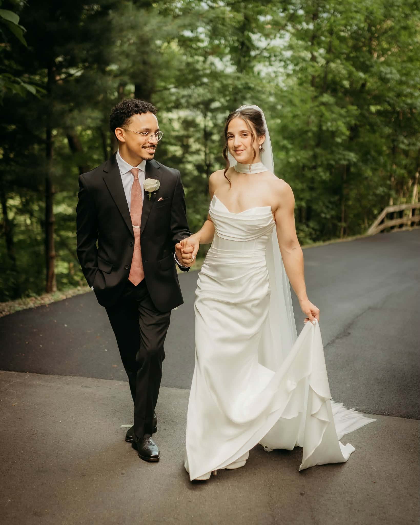 Newlyweds walking together along a quiet forest road