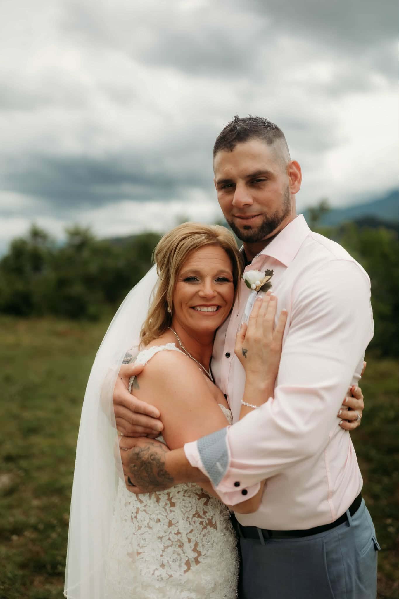 Bride displaying her wedding ring beside her groom
