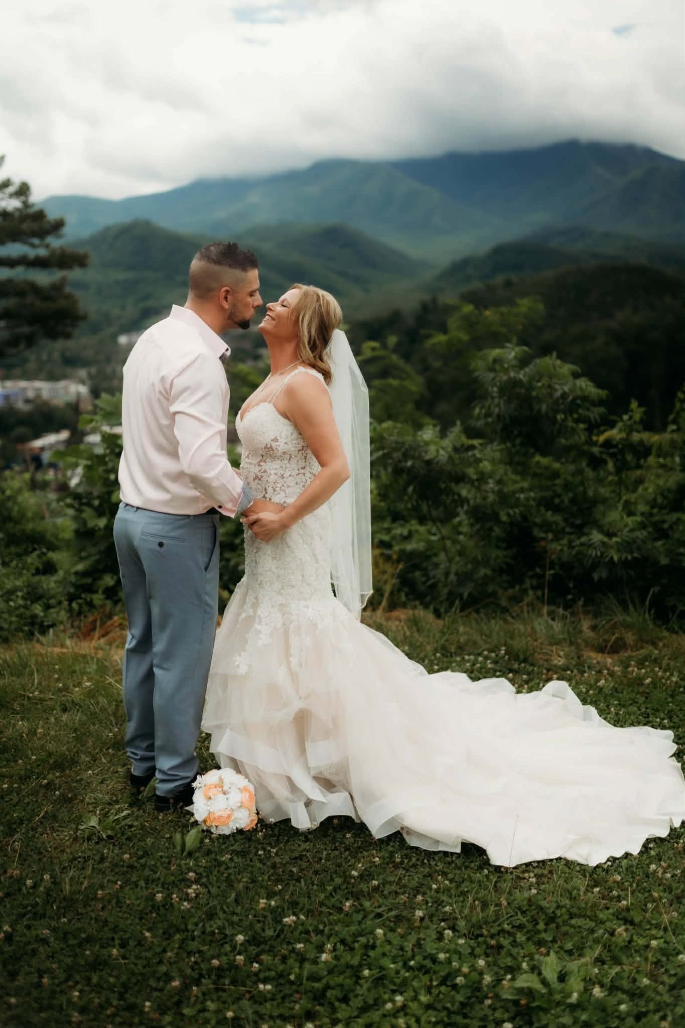 Newlyweds kissing at a scenic mountain overlook