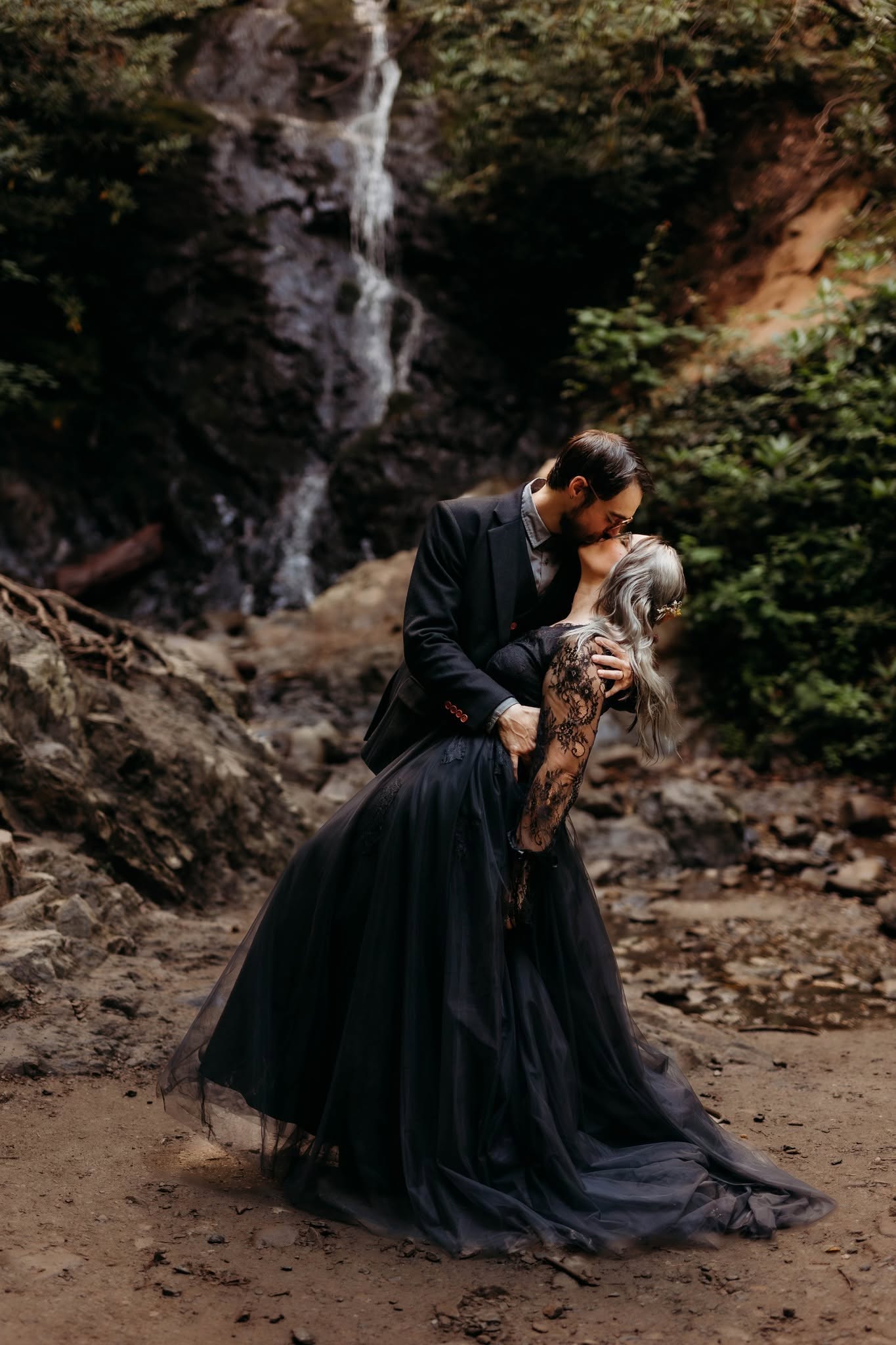 A couple sharing a kiss in front of Cataract Falls near Gatlinburg